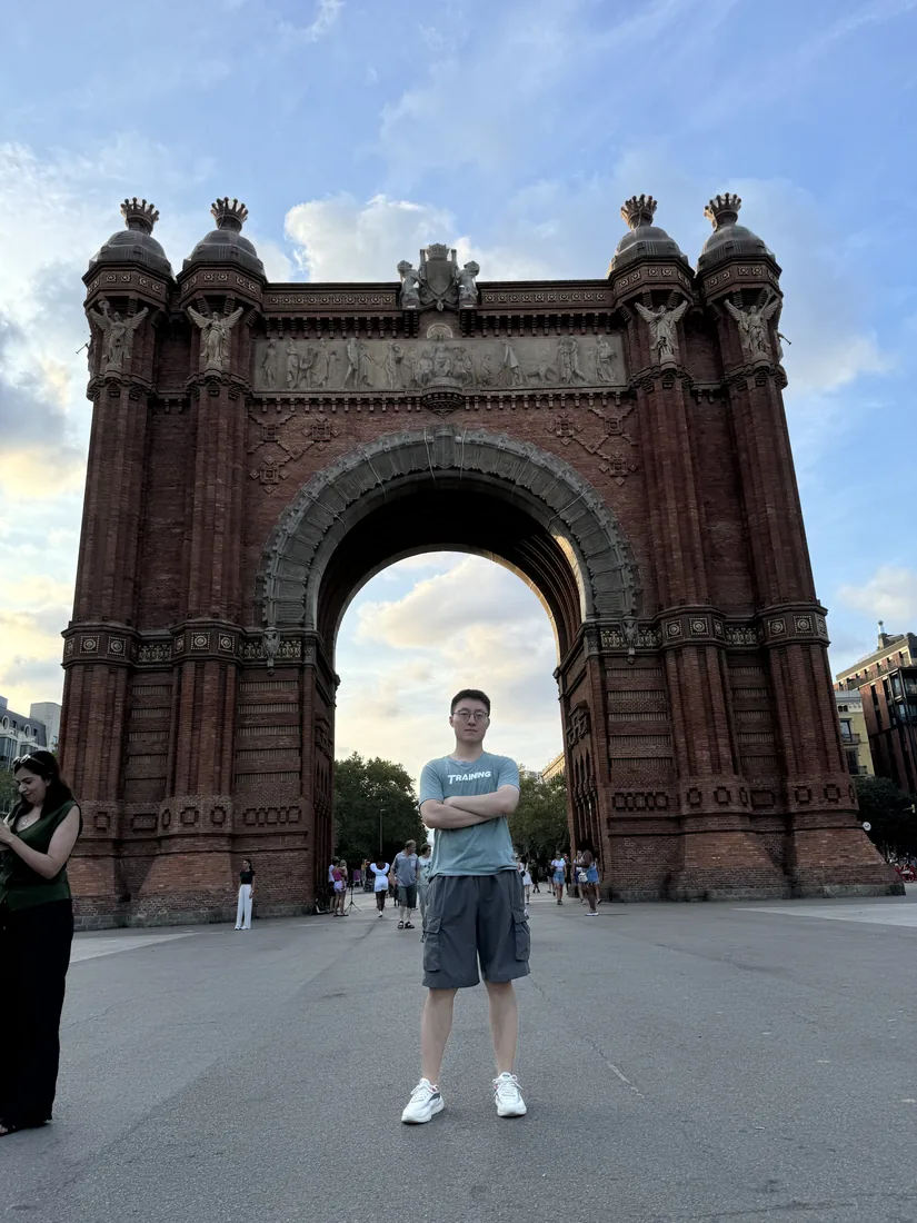 Standing beneath a stone arch in Madrid.