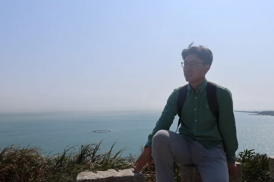 Sitting on rocks overlooking the coast in Pingtan.