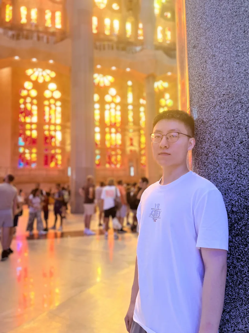 Inside the Sagrada Família with colorful light from stained-glass windows.