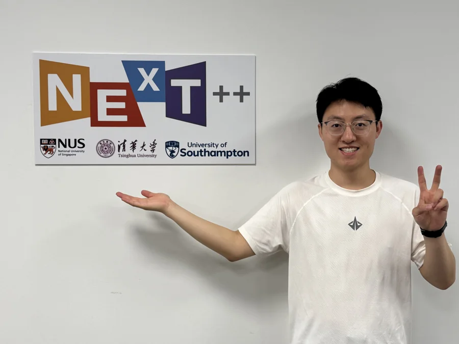 Standing beside the NExT++ sign at NUS.